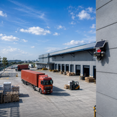 Red truck parked outside a warehouse with a clear blue sky.